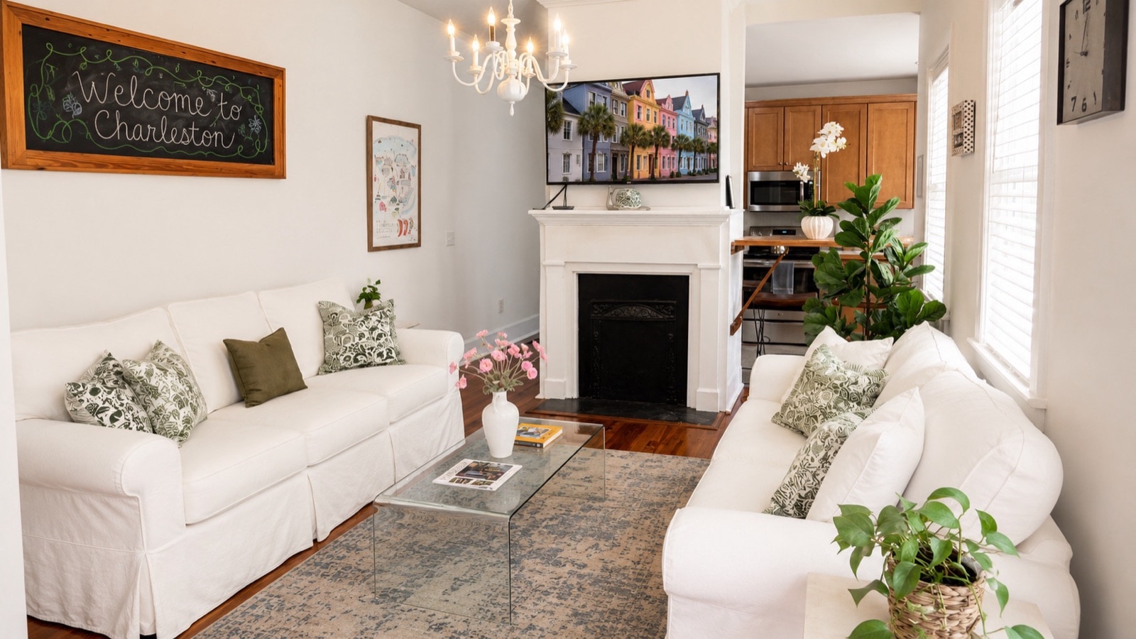 Both sofas around the 1852 fireplace, chandelier above, Welcome to Charleston chalkboard on the mantel wall