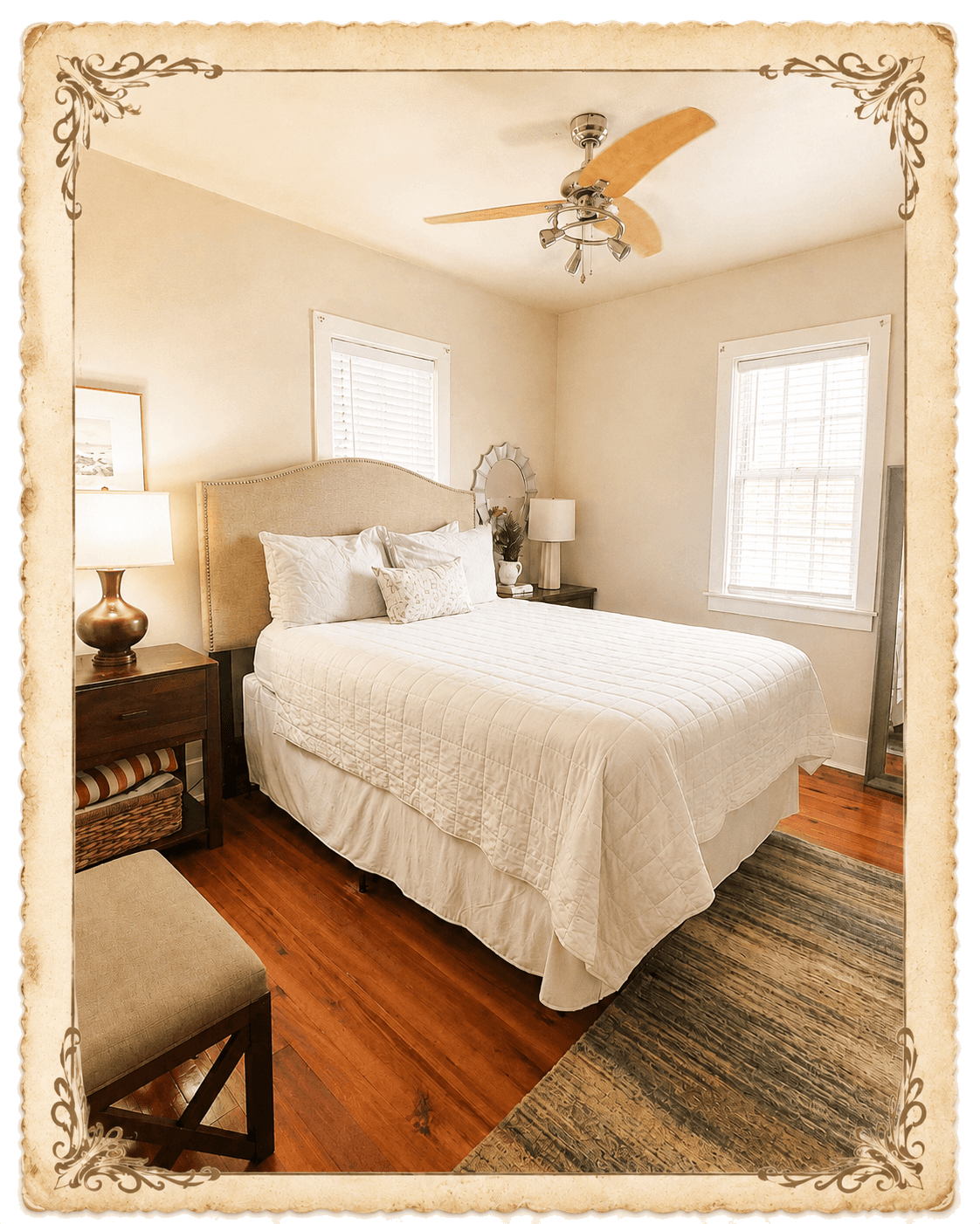 Third bedroom — queen bed with cream quilted bedding, upholstered headboard, sunburst mirror